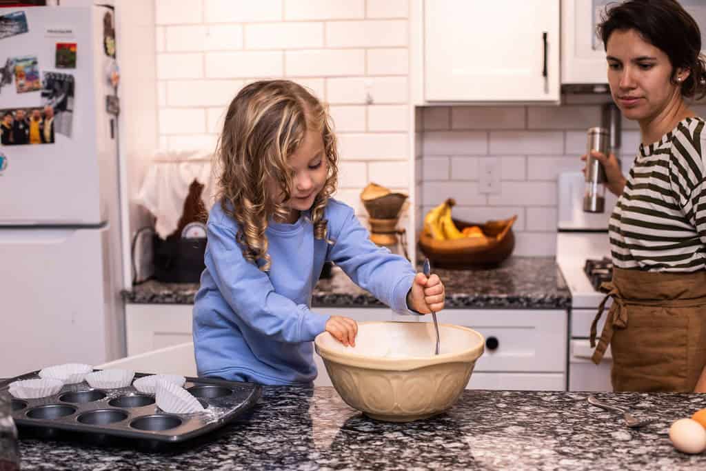 toddler stirring ingredients in a bowl