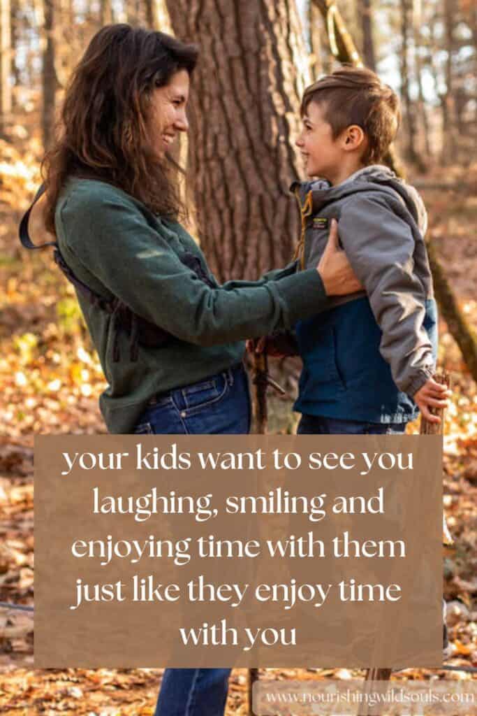 mother and son in woods smiling at each other, quote:your kids want to see you laughing, smiling and enjoying time with them just like they enjoy time with you