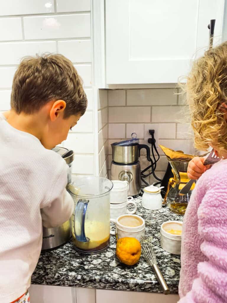 boy and girl making juice with a juicer helping with family chores