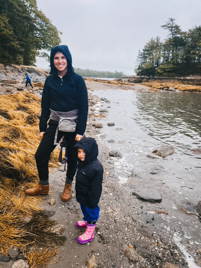 mother and daughter hiking in rain gear while camping, rainy day camping activity for families