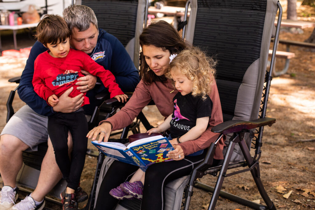 family reading together while on a camping trip using a rest time camping activity for families
