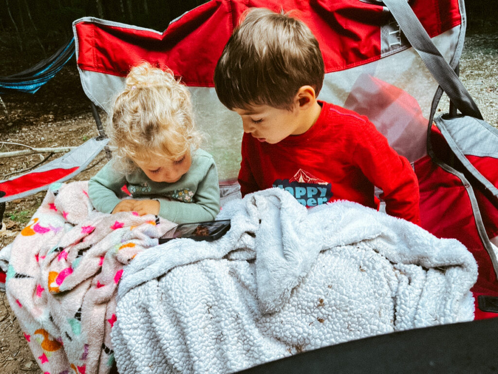 kids watching a tv show while camping, a quiet time camping activity for families