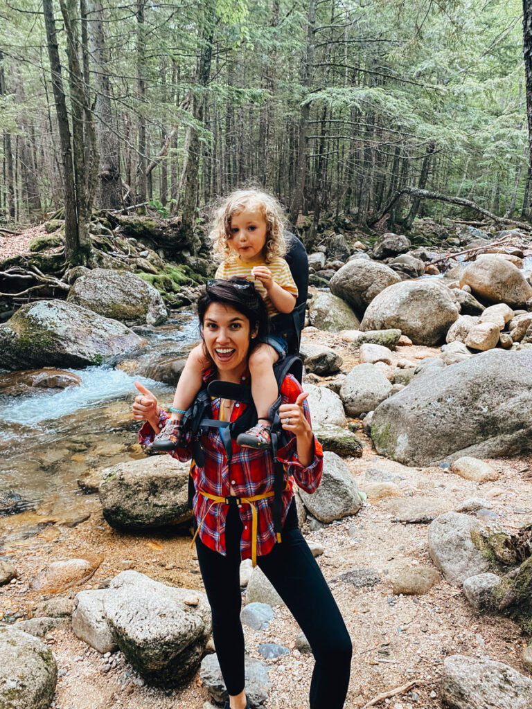 mother carrying daughter during a camping trip